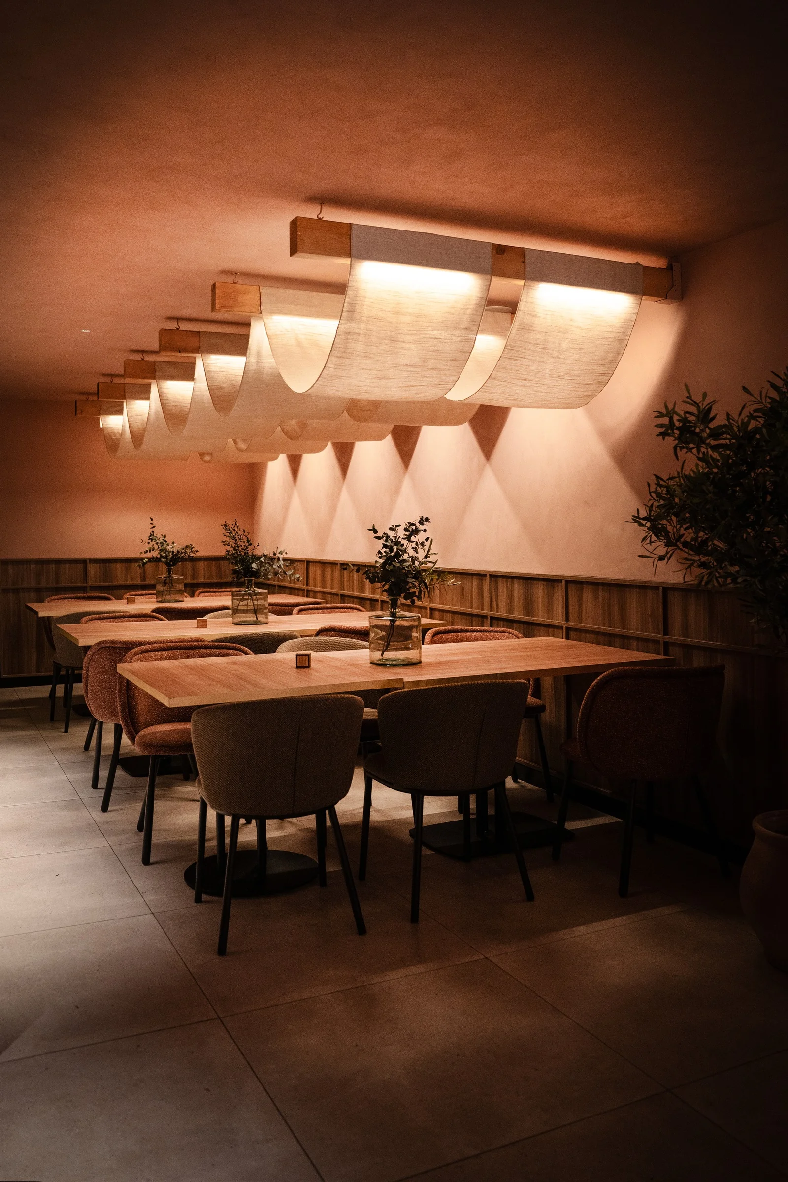 Comedor de Gulliver con mesas largas y telas luminosas